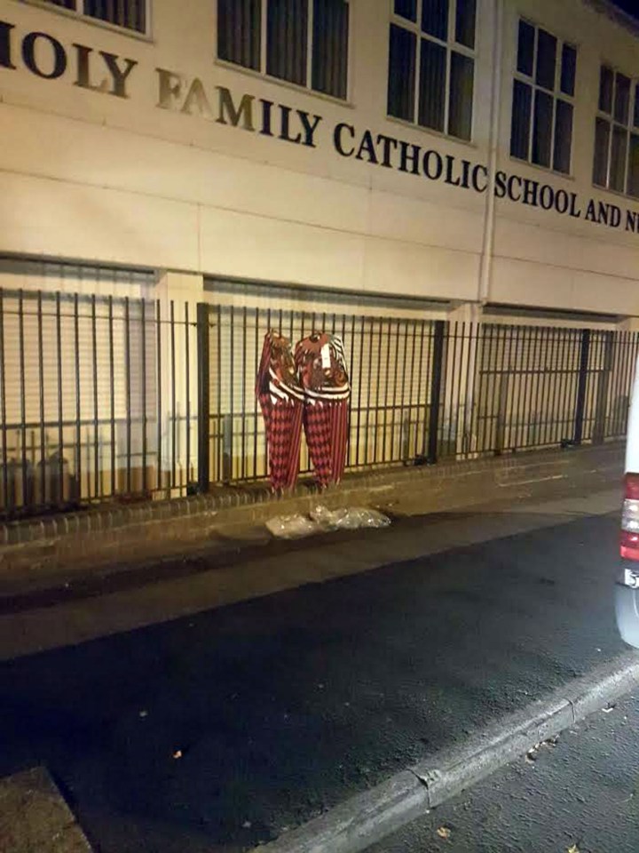  A Birmingham school was targeted by pranksters who hung two killer clown costumes on the rails late at night