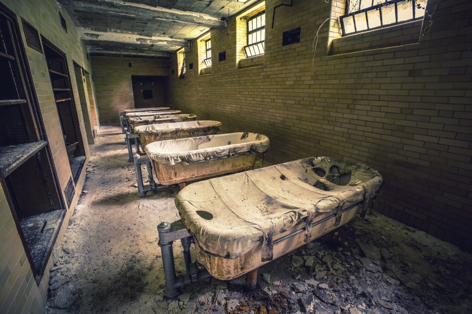  What were once baths lay covered in rubble and dust in an eerie former asylum