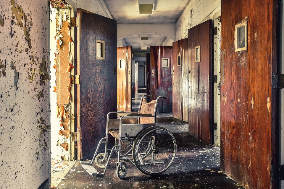  A lone wheelchair sits in a desolate corridor where it was last used by its patient