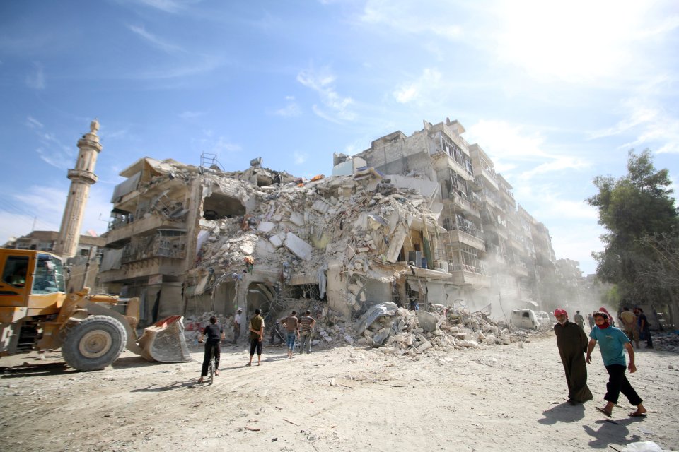  Rescue workers survey the wreckage of a building in the beseiged city of Aleppo, Syria