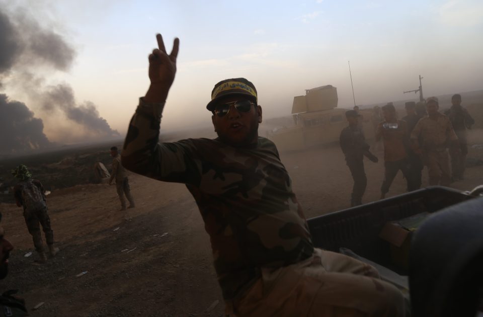  An Iraqi army fighter flashes the peace sign after arriving in nearby Hut