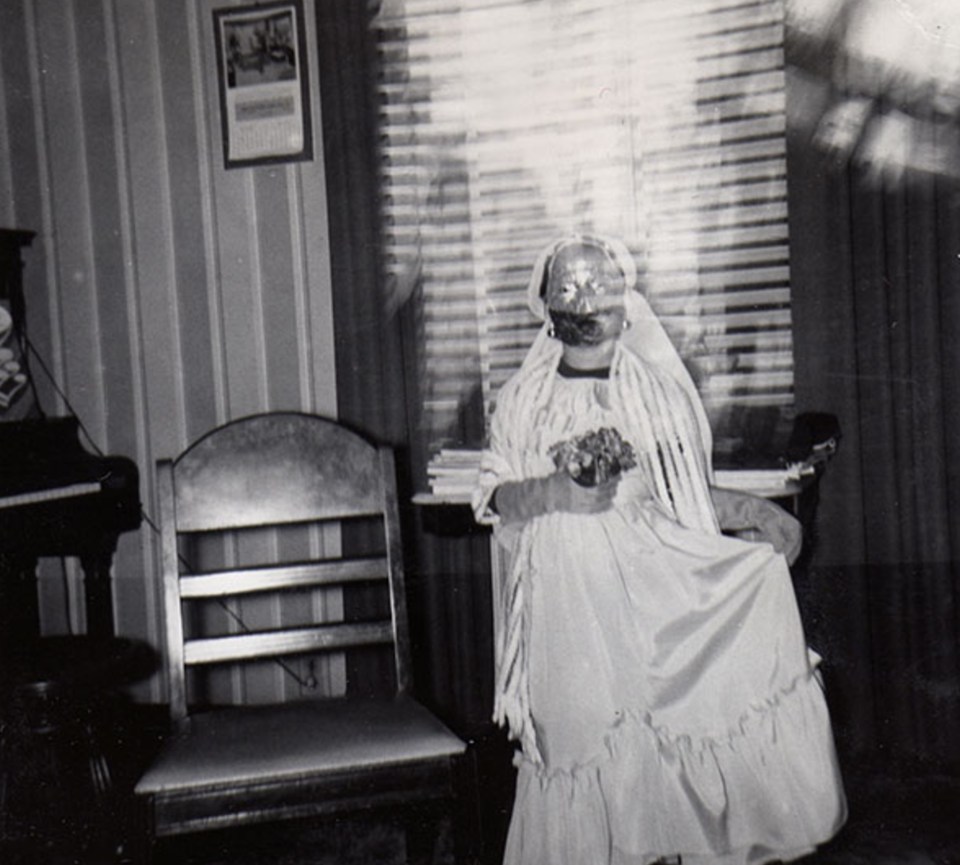  A woman wears what appears to be a bridal-themed costume complete with veil and flowers