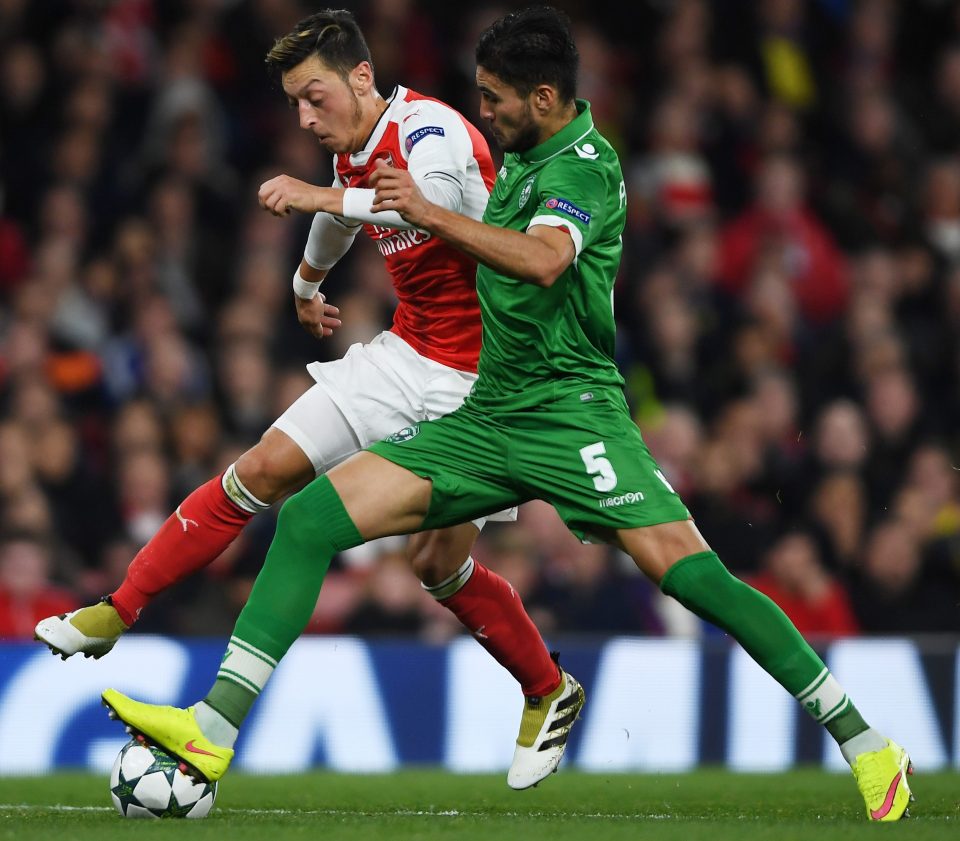  Mesut Ozil holds off the challenge of Jose Luis Palomino as Arsenal totally dominate