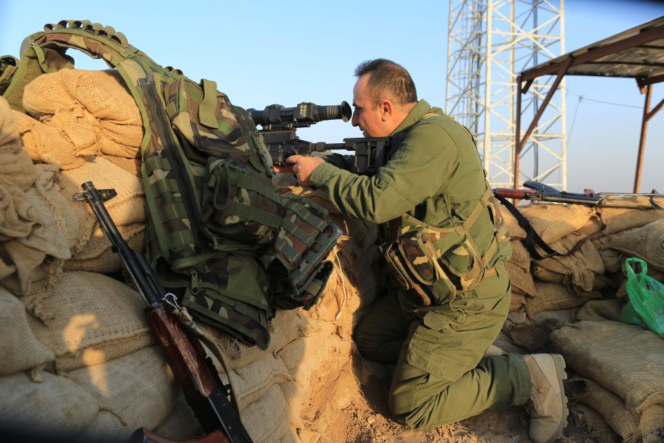  A Kurdish sniper holds a position outside the town of Naweran