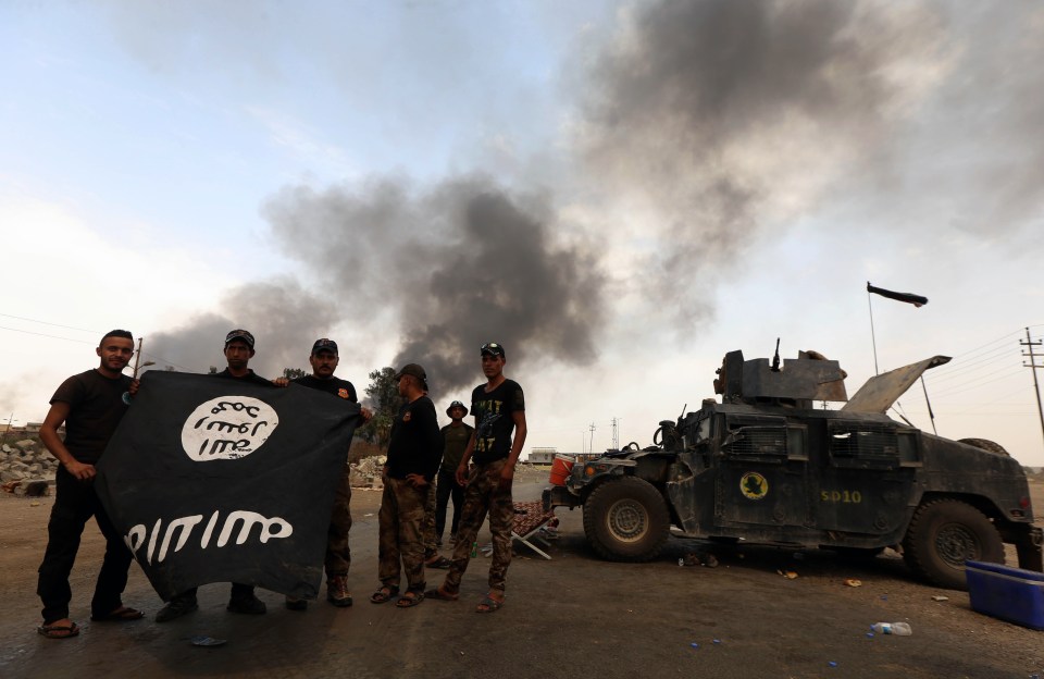  Moving quickly... Iraqi forces hold IS flag upside down as they celebrate taking new territory