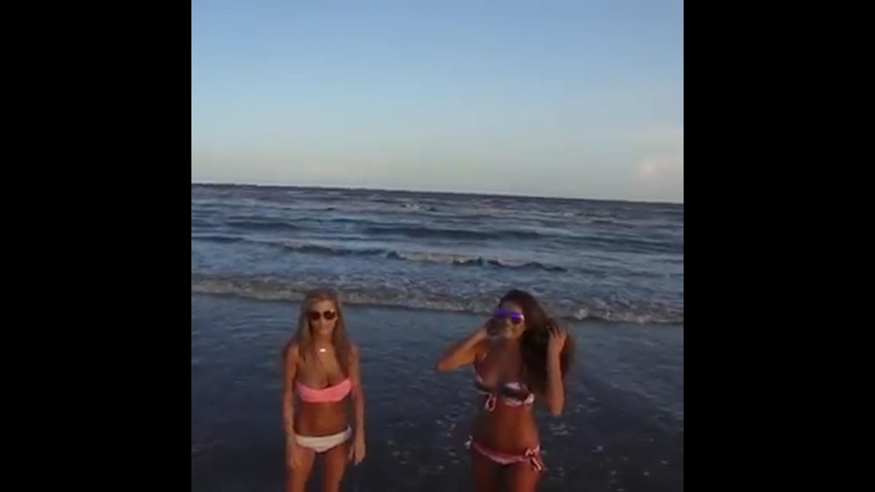  The two gorgeous models turn to the camera during photo shoot ready to dash into the surf