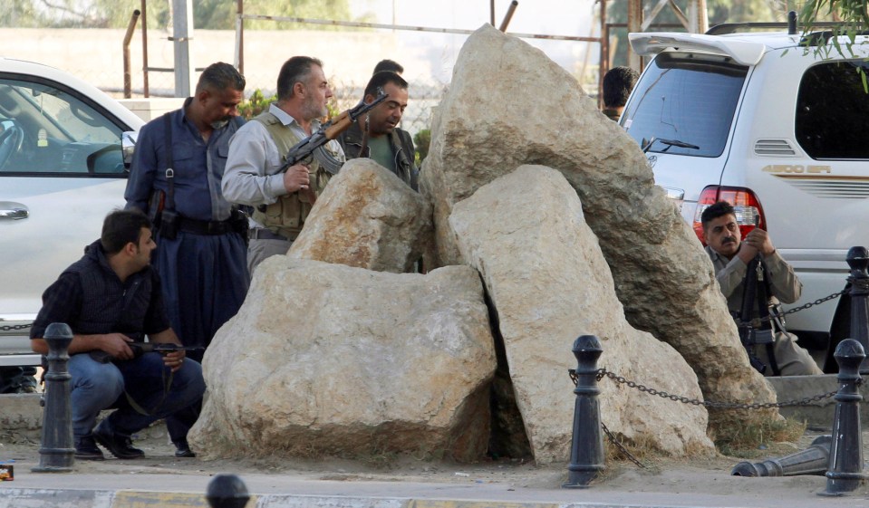  Peshmerga forces take shelter behind a rock during the Kirkuk attack