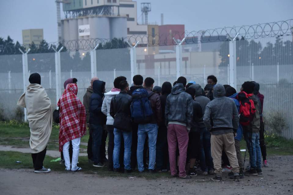  Migrants listen to an official during the full evacuation of the Calais camp