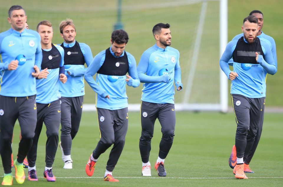  Sergio Aguero (centre) tucks his hands in his training top as he takes a jog with his team-mates