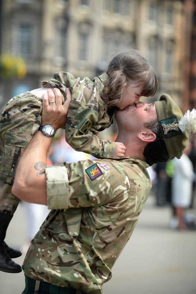 Corporal Sean Neill, from Kilmarnock, kissing his daughter Madison in the streets of Glasgow after the 400 strong Homecoming Parade