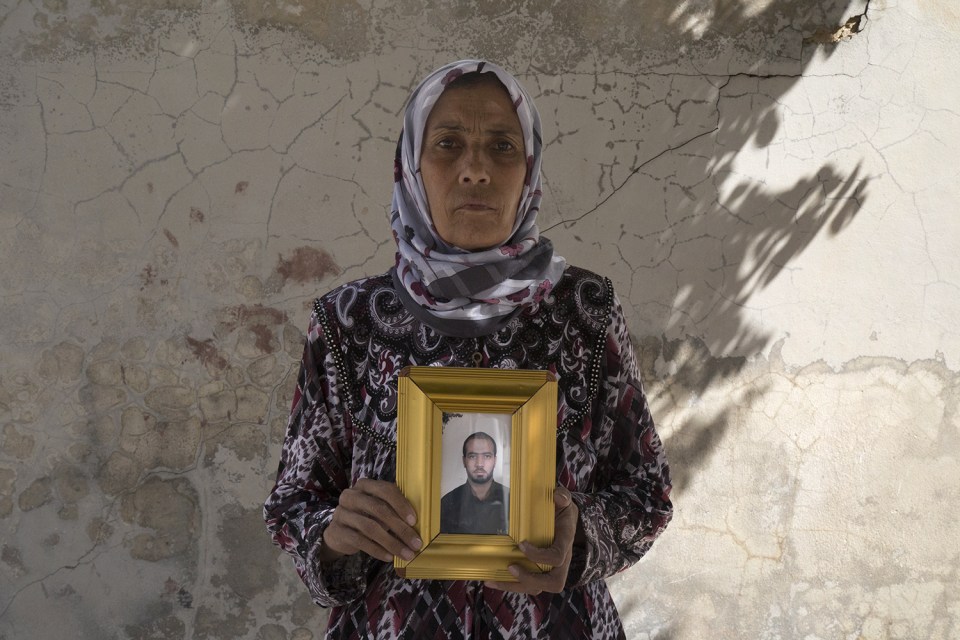  Bereaved mum Zakia Hassan holds a photo of her son, Ibrahim Hammud, 35, who detonated an explosive device when he stepped on a mattress