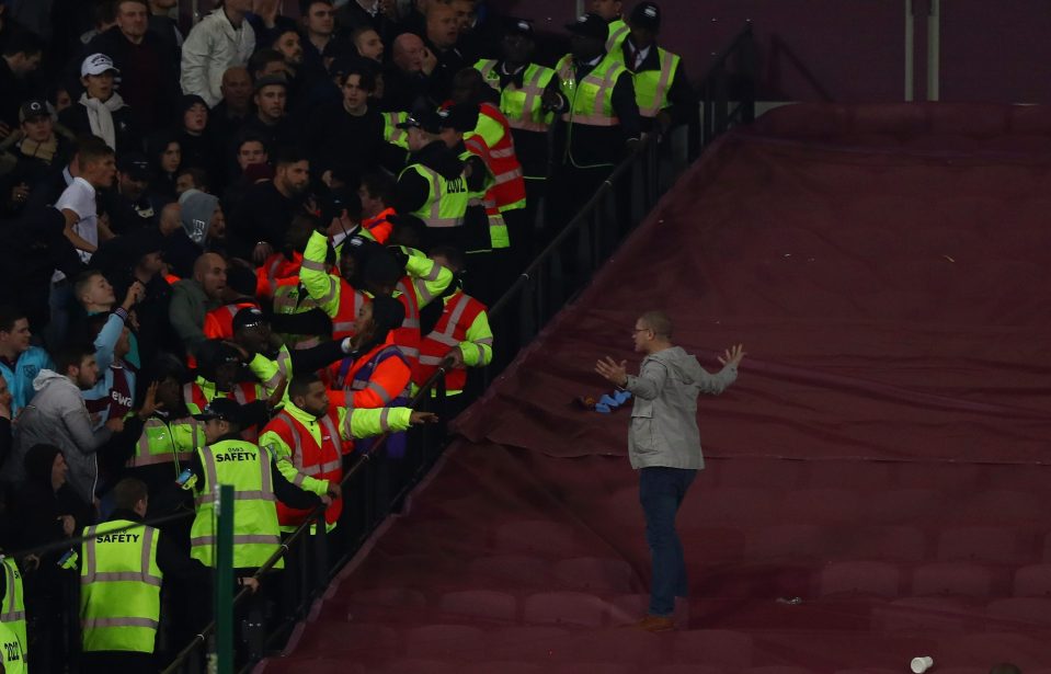 The fan is instructed by safety officers after breaching the stands