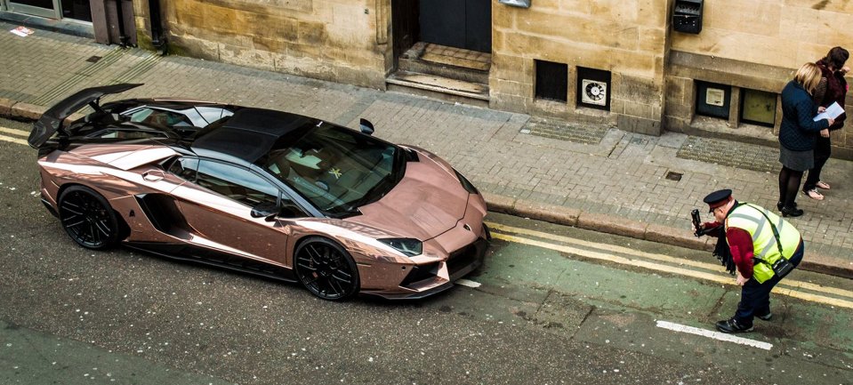  Traffic warden takes a close look at the supercar that was parked on double yellow lines outside a Leicester nightclub