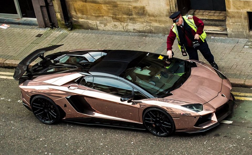  A traffic warden fixes a £35 penalty to the windscreen of the gleaming Lamborghini Avendator SV