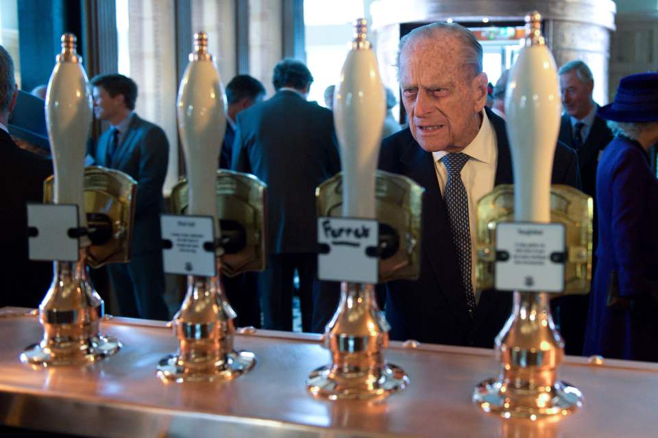  Prince Philip carefully studies what ales are on offer on tap in the pub on Queen Mother Square