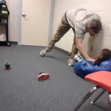  The boy whimpers as the teacher pins him down