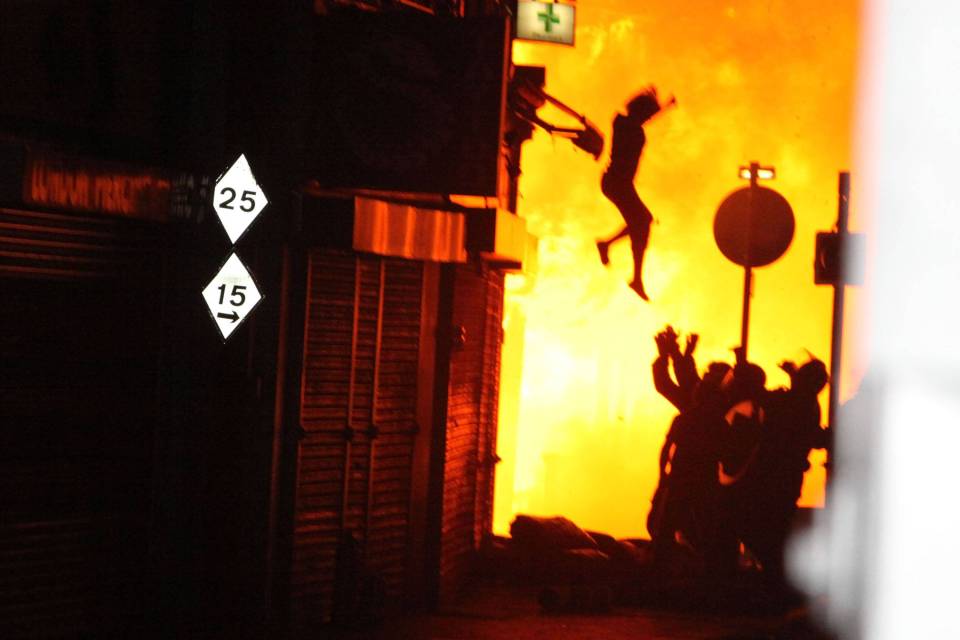  A woman can be seen jumping from a burning building in Croydon, after rioting took place in August 2011