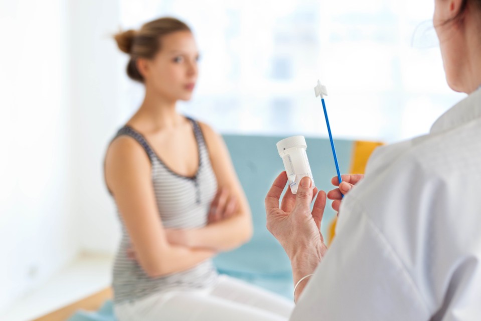 Gynecologist performing a cervical smear or pap test on a teenage patient