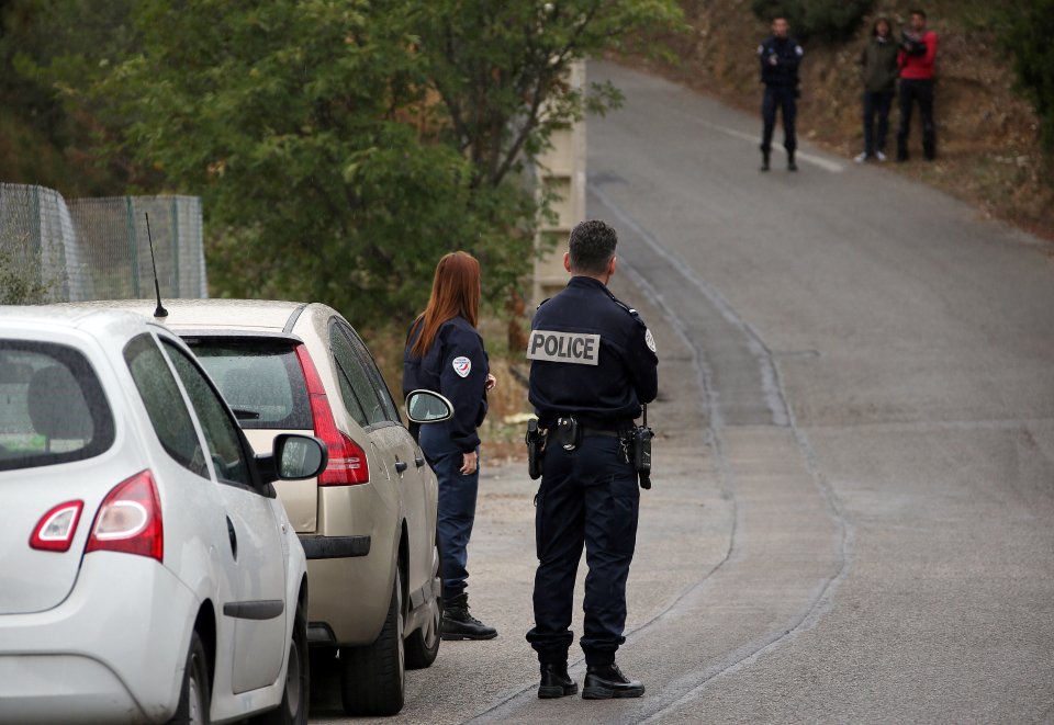  French police officers stand at the scene where Ms Veyrac was allegedly kidnapped near her home in Nice