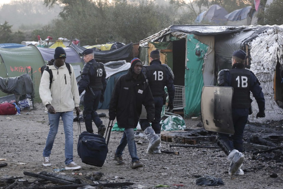  Migrants move out of the camp before it was dismantled last week