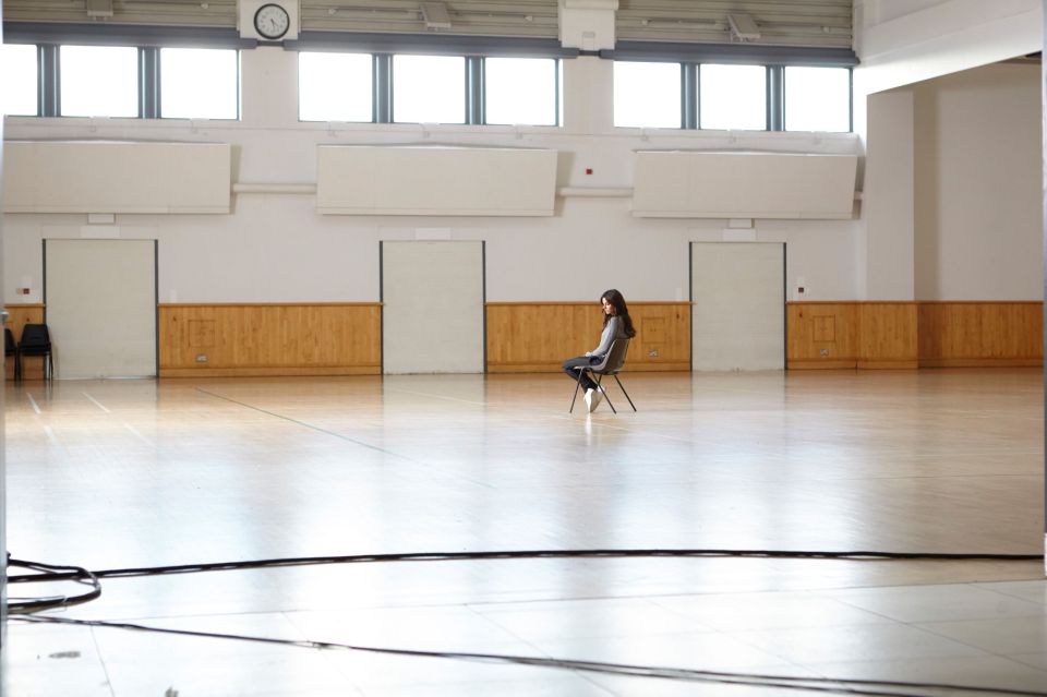  Cheryl cuts a lonely figure as she sits alone in a school hall