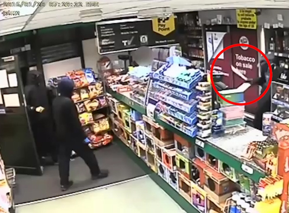  The men brandished the huge blade at the shopkeeper, who can be seen cowering in the corner