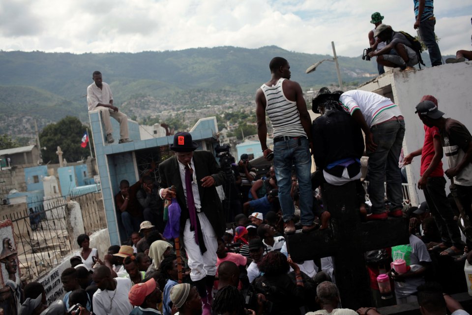  Voodoo believers stand around, and on, the cross of Baron Samedi during celebrations