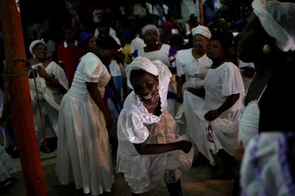  A voodoo believer laughs as she dances during a ceremony at the Peristil a voodoo temple in Haiti