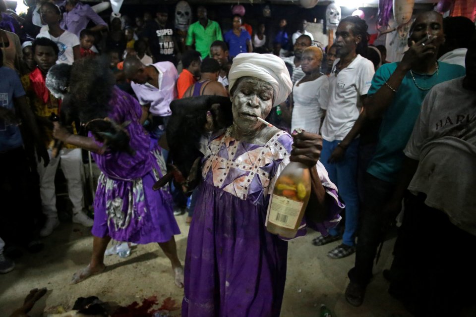  Spiritual revellers wear white face paint and drink spicy rum during the two day festival