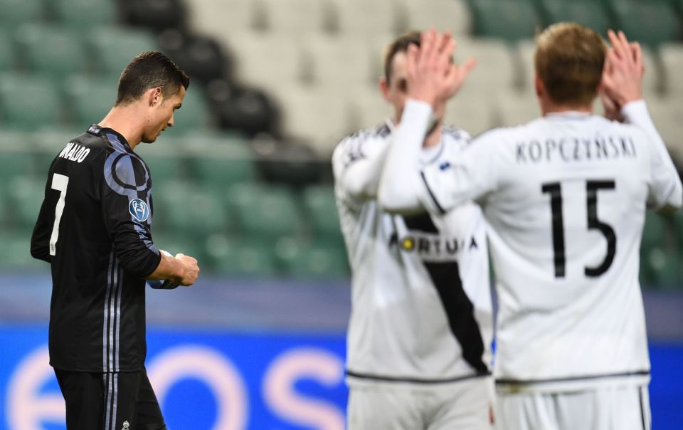 Real Madrid's Portuguese forward Cristiano Ronaldo walks off the pitch as Warsaw players celebrate in UEFA Champions League