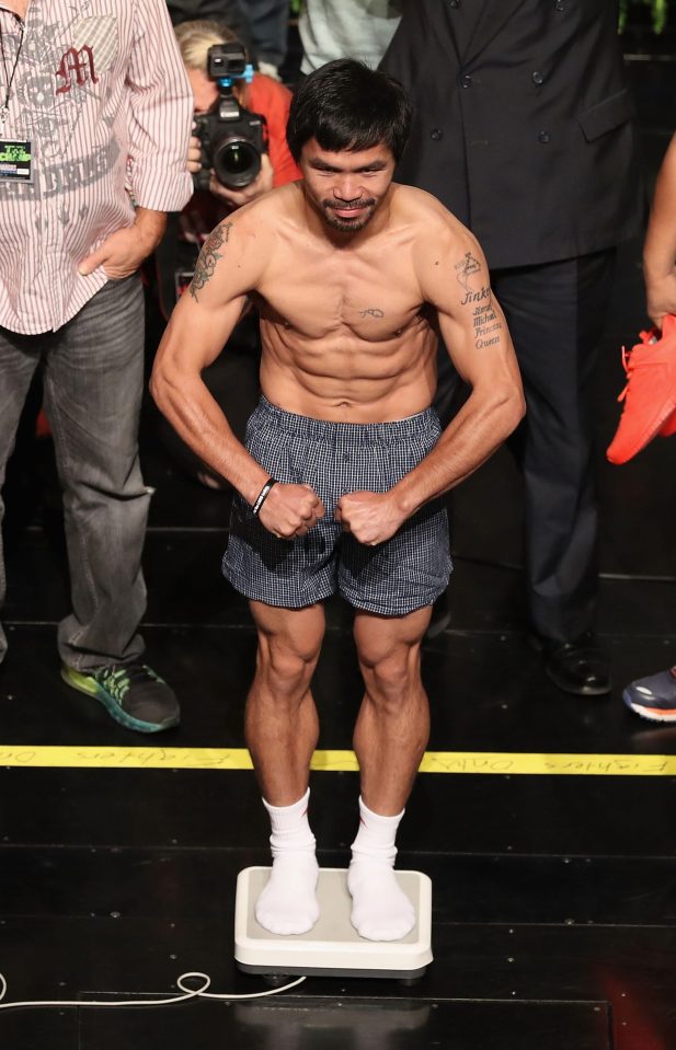  A ripped Many Pacquiao flexes on the stage as he weighs in