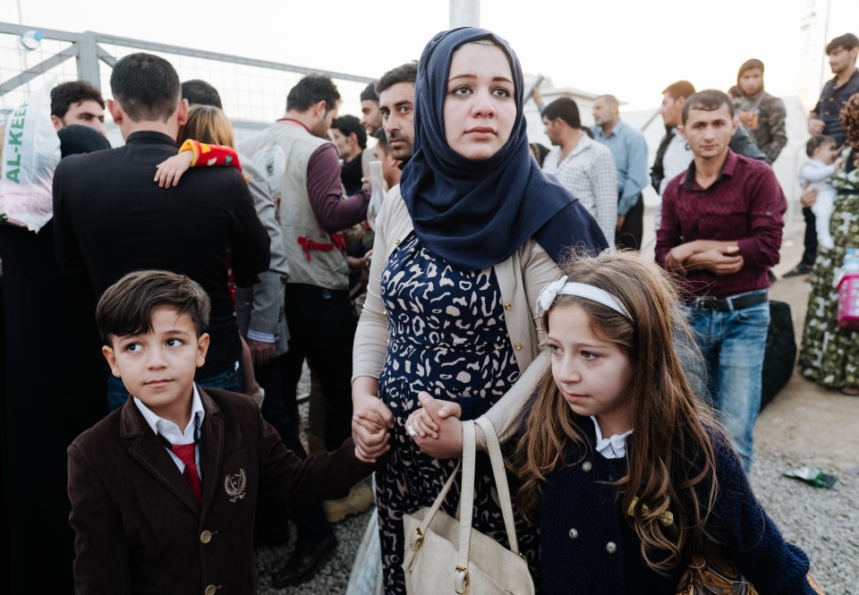  Families are reunited through the wire of the camp after years apart