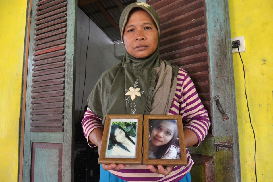  Mother of Indonesian murder victim Sumarti Ningsih holds photos of her beloved daughter