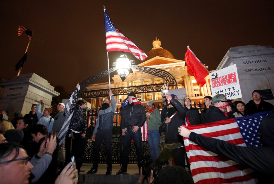  Protesters stand on the state house steps during a march against Donald Trump in Boston