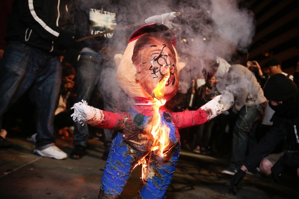  Fiery rage... An effigy of Trump is burned in downtown Oakland, California