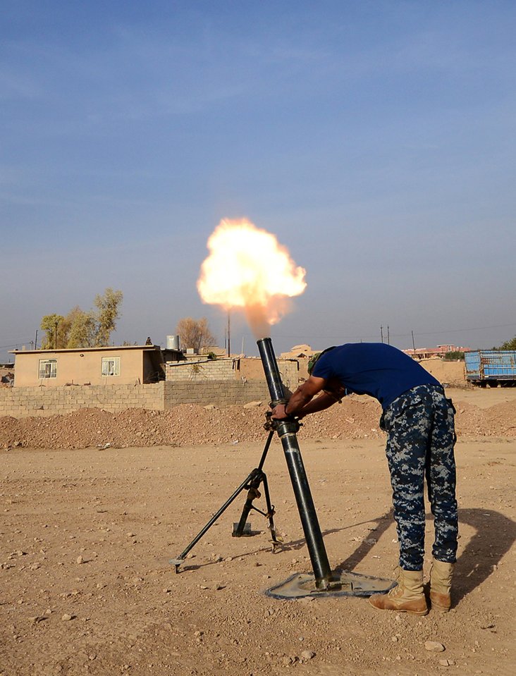  An Iraqi federal police officer fires a mortar shell at an ISIS target