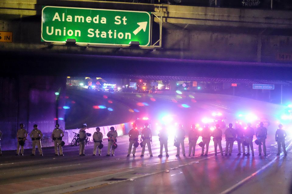  Police form a line across the road as demonstrators shut down the 101 Freeway