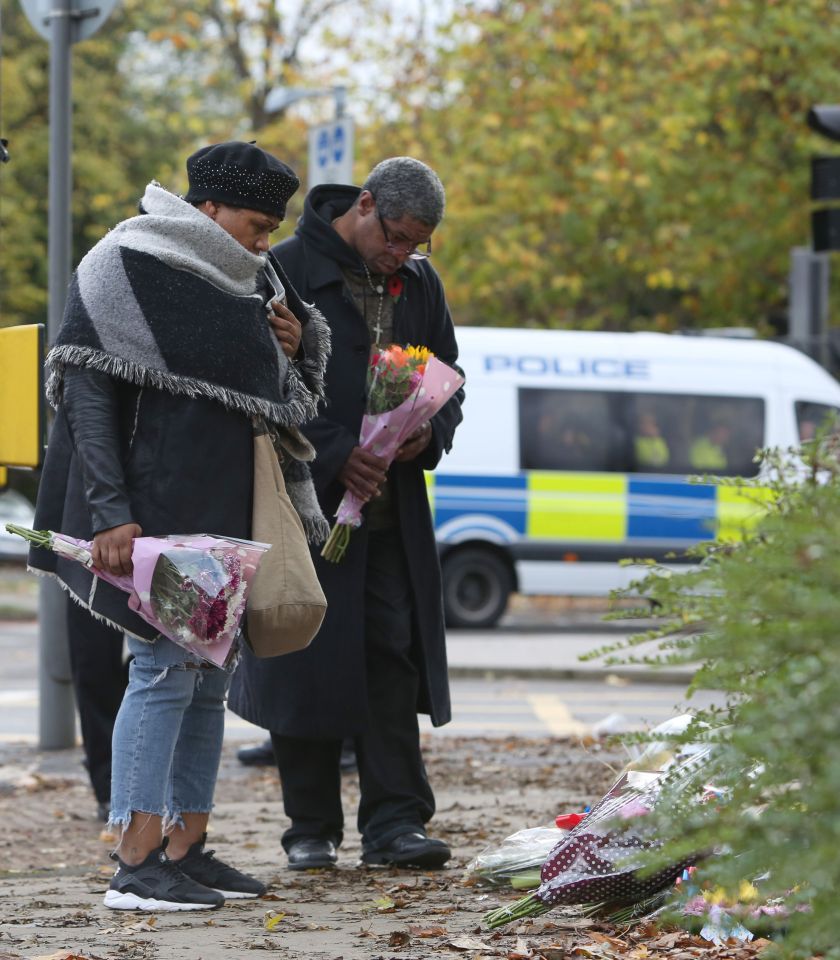  People lay floral tributes at the scene as work continues after the train derailment