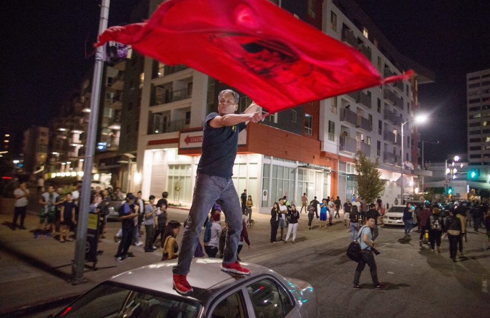  A man climbed on top of a car in Los Angeles, California, as the country was rocked by Trump's victory