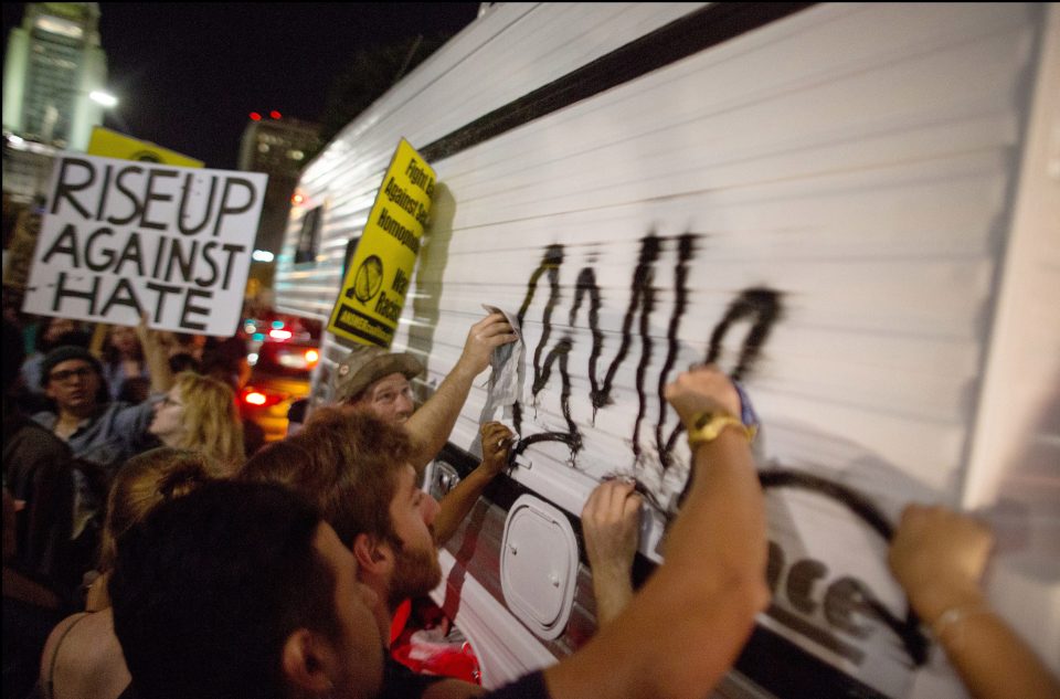  'Rise up against hate': Protesters scrawled on the side of a van as they tried to make their voices heard