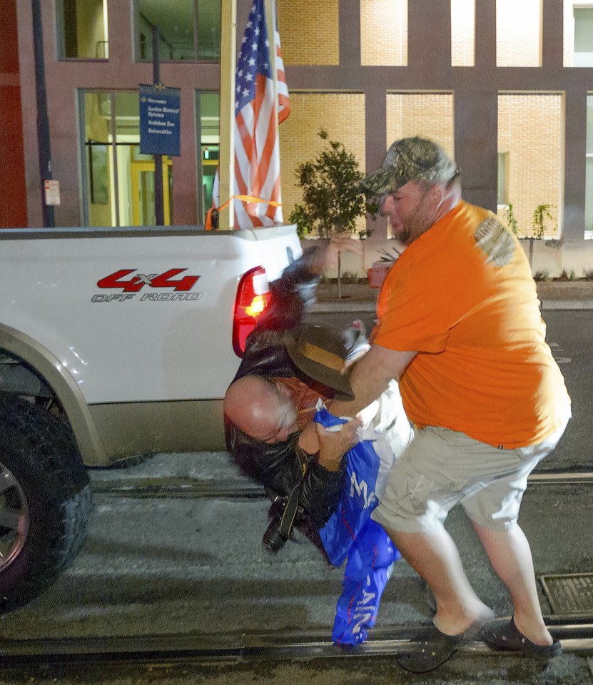  The pro-Clinton supporter was nearly thrown to the ground as the men tried to settle their differences