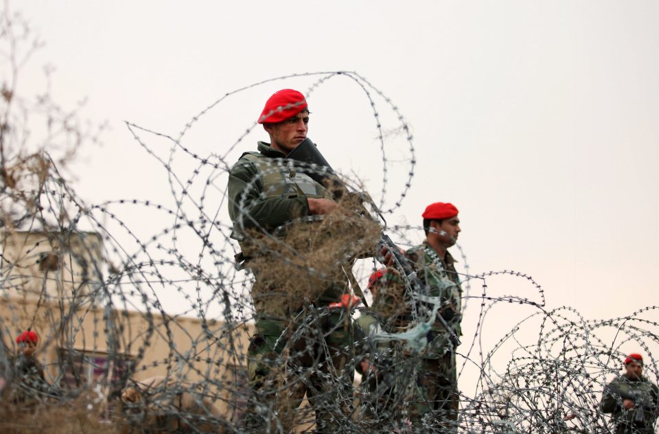 Members of the Afghan security services standing guard on a roadside amid intensified security following the suicide 