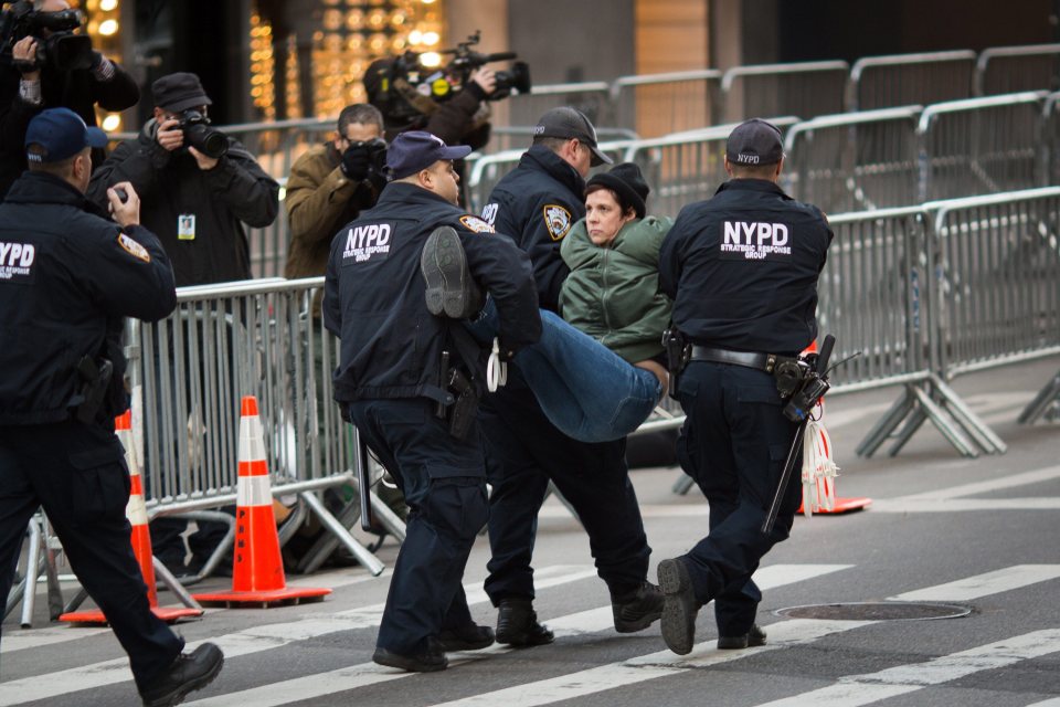  Officers carry away a protester who had breached the barricade in front of Trump Tower