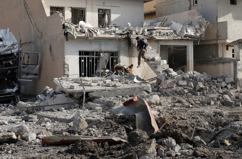 An Iraqi special forces soldier jumps form stairs after an Islamic State suicide car bomb attack during gunfight in Tahrir neighbourhood of Mosul