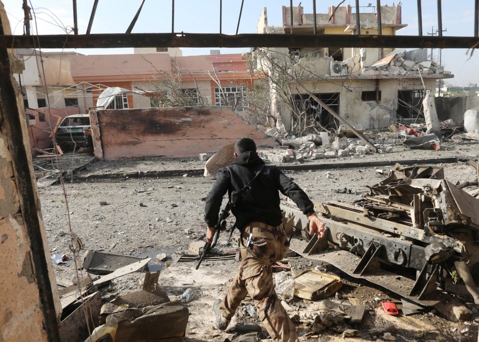 An Iraqi special forces soldier runs across a street after an Islamic State suicide car bomb attack during gunfight in Tahrir neighbourhood of Mosul