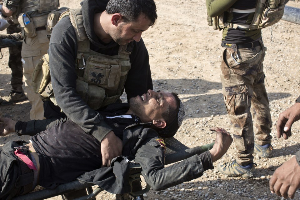  A wounded Iraqi special forces soldier gets treatment at a field clinic