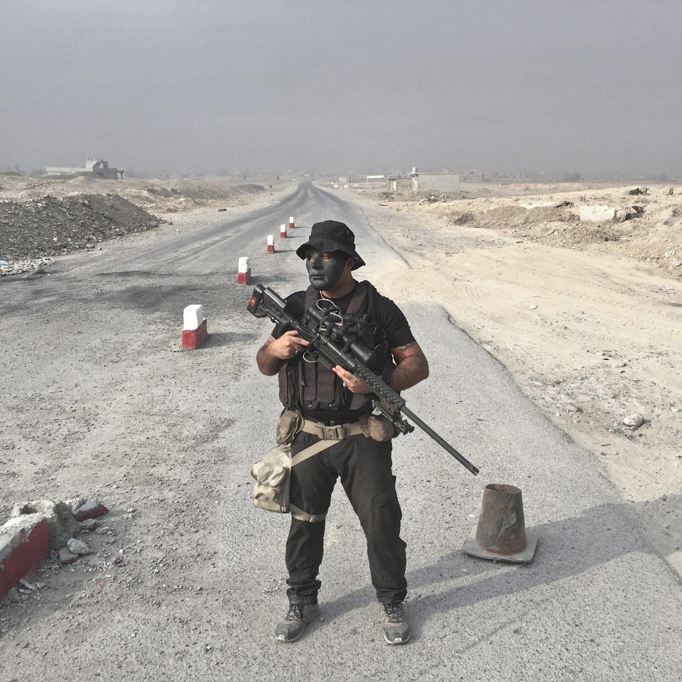  Sniper Riyad Jaffar, 27, of Baghdad, guards a checkpoint in Qayara, Iraq