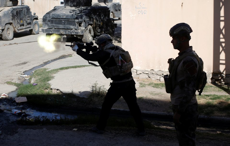 An Iraqi special forces soldier fires his rifle at Islamic State fighters in Mosul