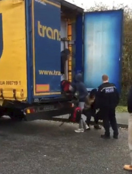  Footage shows a handful of people with rucksacks climbing out of the Romanian lorry after it was stopped by a police van