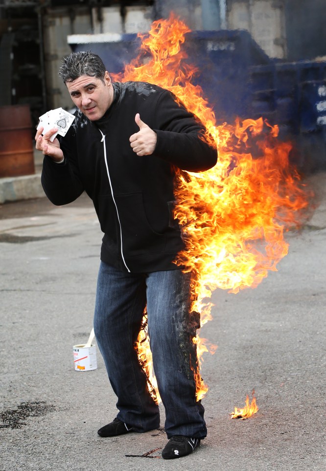  The stuntman casually completes a card trick while on fire